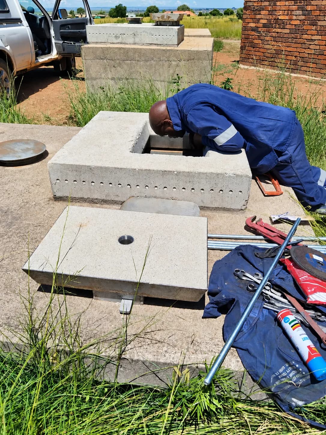 Technician working at an open valve chamber on site